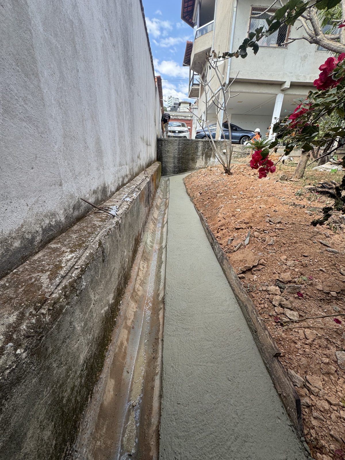 Passagem lateral com contrapiso e canaleta de drenagem executados em concreto